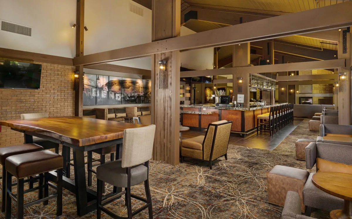 This image shows the interior of CURRENTS Lounge, with a large wooden bar, cozy and flexible seating suitable for families, and stylish lighting that creates a relaxed, social setting. The arrangements encourage both casual dining and memorable family conversations, matching the section’s emphasis on kid-friendly meals and shared moments.